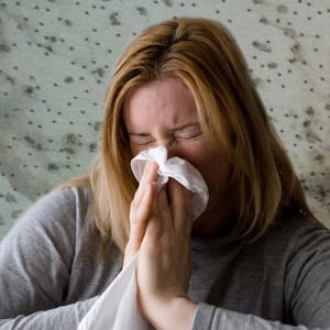 Photo of Woman Sneezing from a Mold Allergy