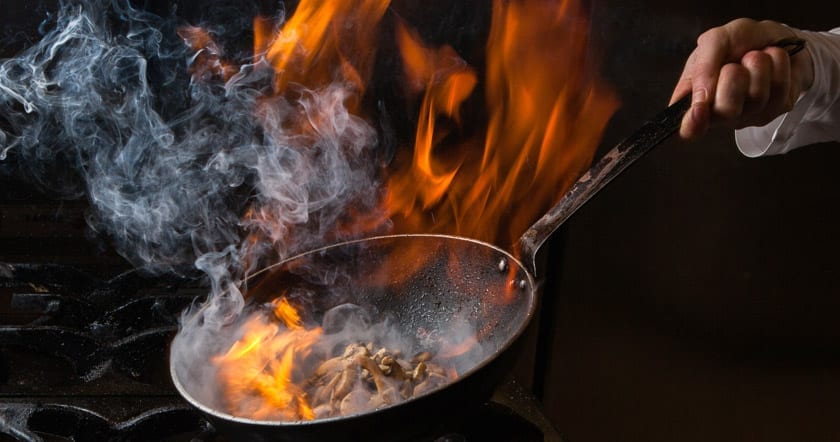 cooking with fiery hot pan on stove