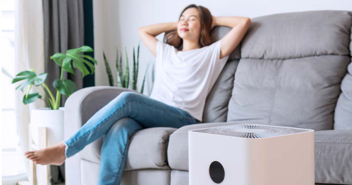 woman lounging on couch with purifier in focus