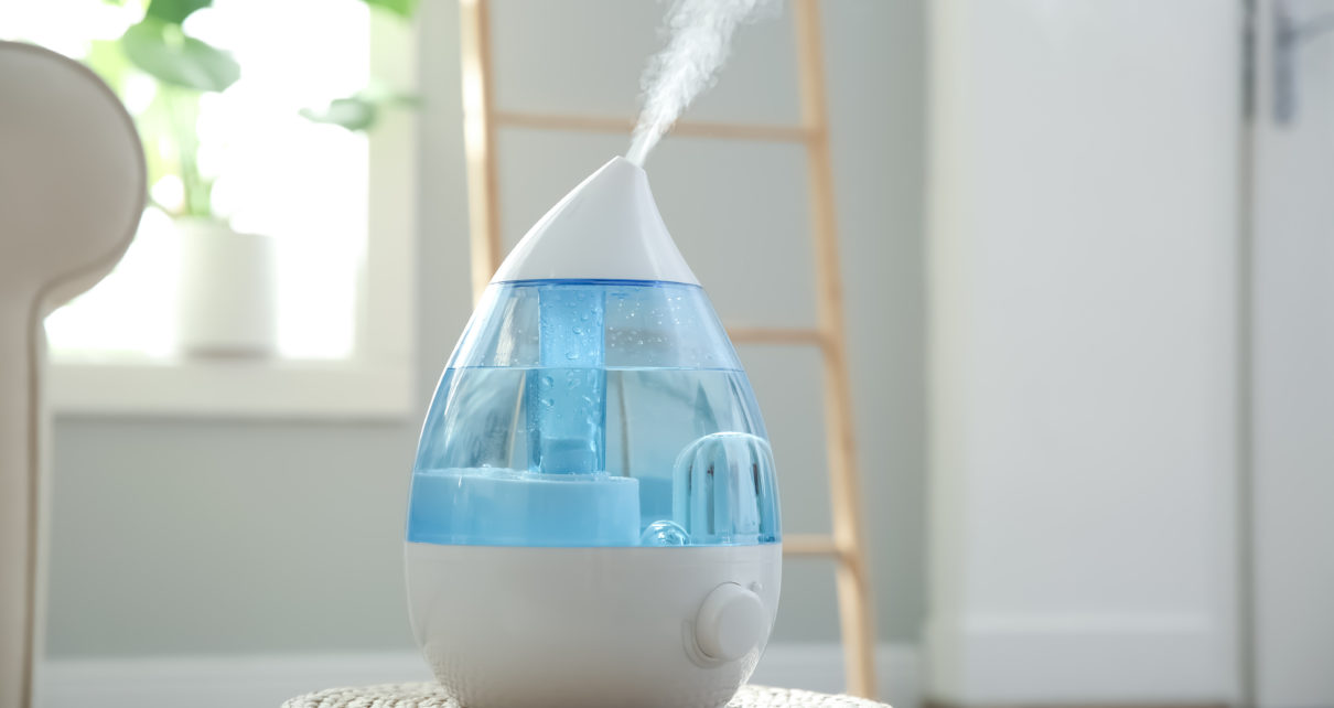 Modern air humidifier on wicker pouf indoors