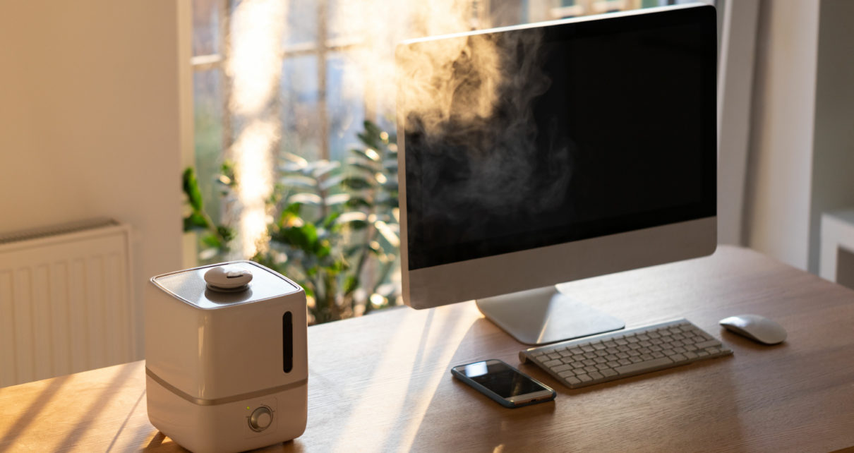 Close up of desktop air purifier and aroma oil diffuser on desk at home