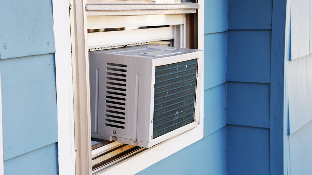 old window air conditioner unit in window of blue house