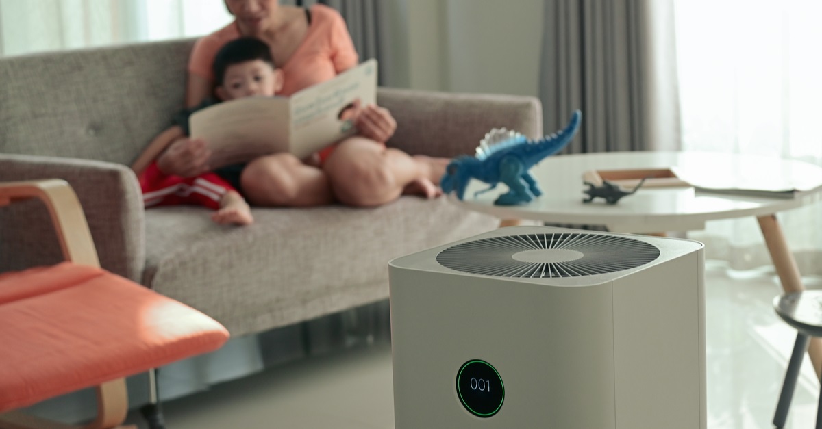 air purifier in living room with mother and kid reading on couch