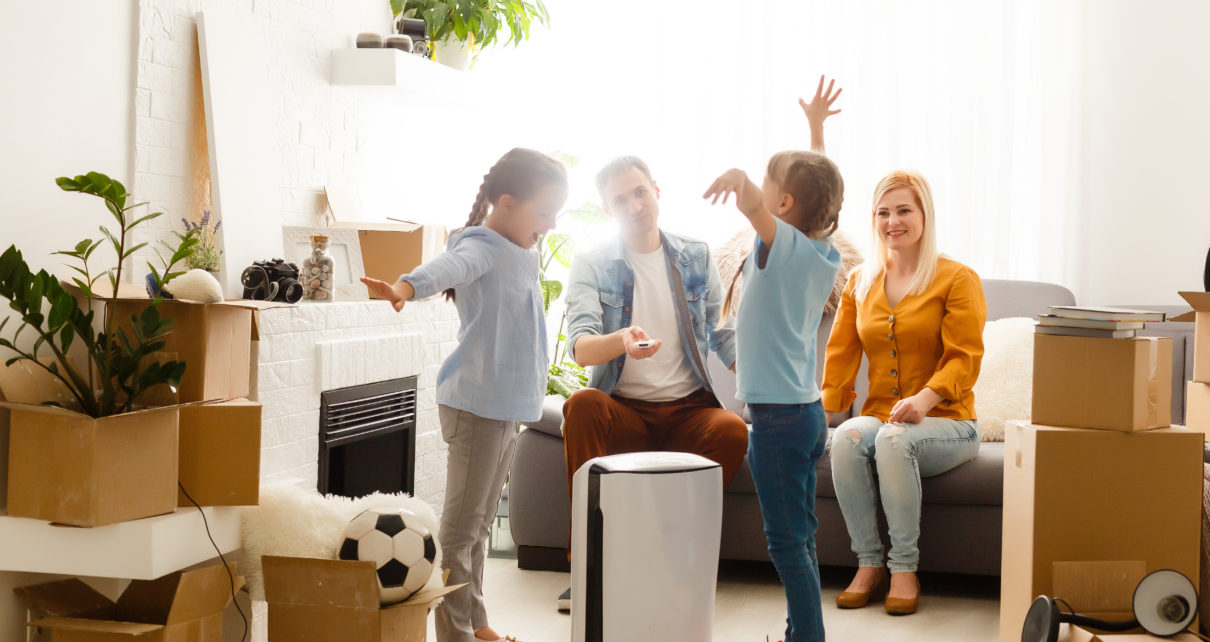 oreck air purifier in living room with family surrounded by moving boxes