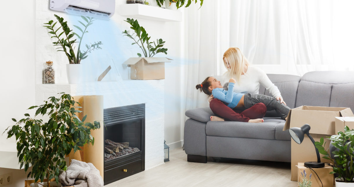 iWave air purifier on wall in living room with mother and daughter playing on couch
