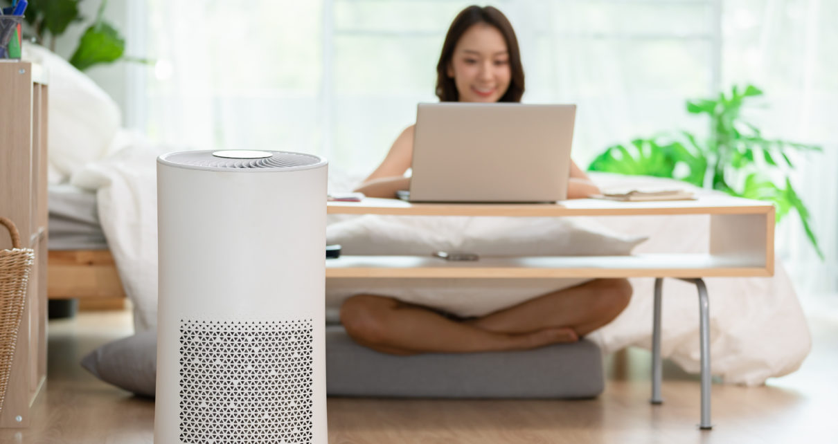 quiet air purifier with woman working on laptop compter on ground