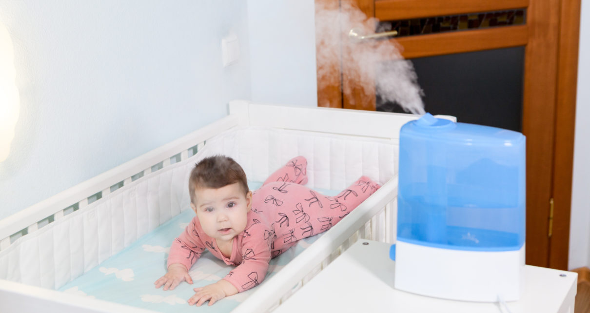 humidifier in baby nursey next to baby in crib