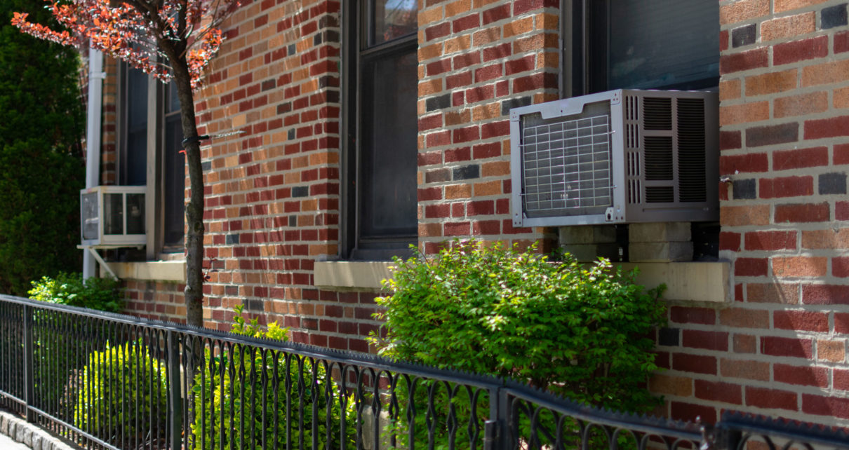 Amana air conditioner in window of brick brownstone home